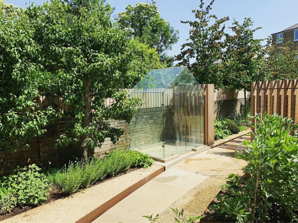 Spot the greenhouse.  @puregreenhouse #framelessglass #greenhouse #garden #garde...