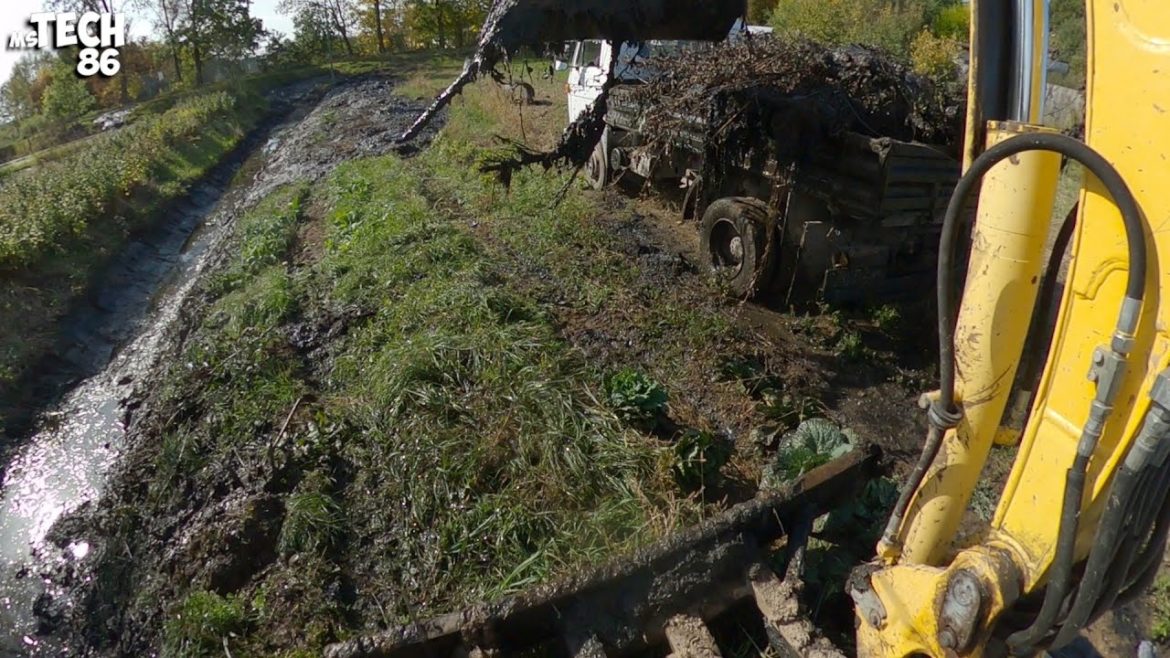 Desilting Dirty And Muddy Drainage Ditch With An Excavator Desilting Dirty And Muddy Drainage Ditch With An Excavator