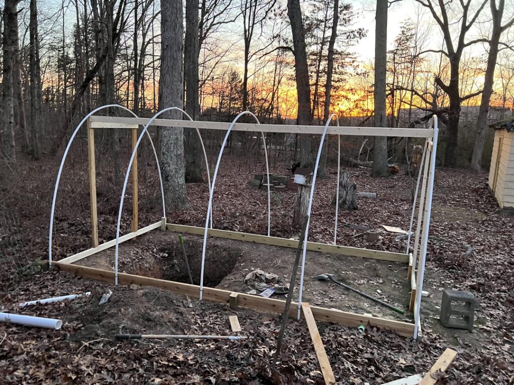 First greenhouse build. Zone 7b. 16’x10’. What can I do with this 5’ deep hole?