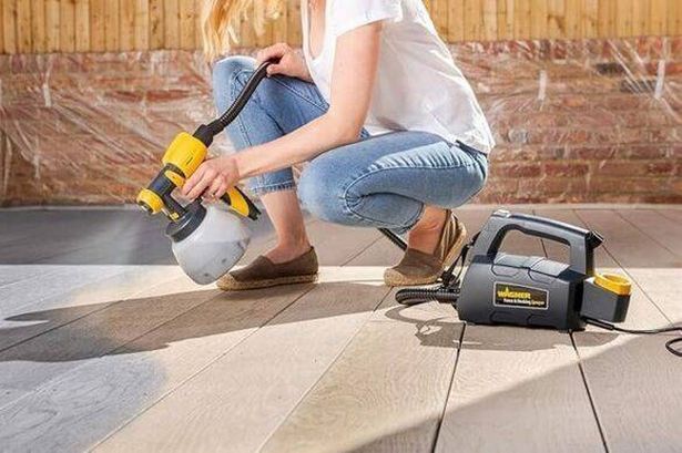 A woman spraying her patio grey