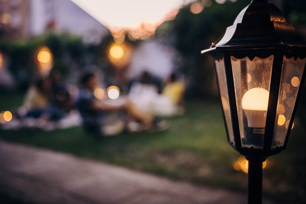 Friends watching movie on the video projector in the backyard garden