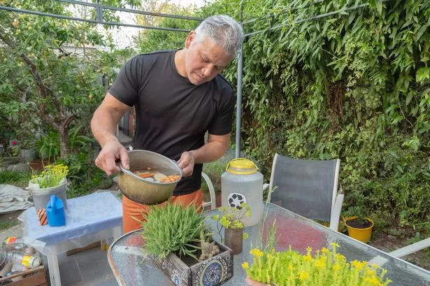 man in the yard watering a plant