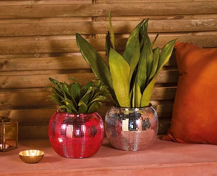 Two disco ball planters with plants.