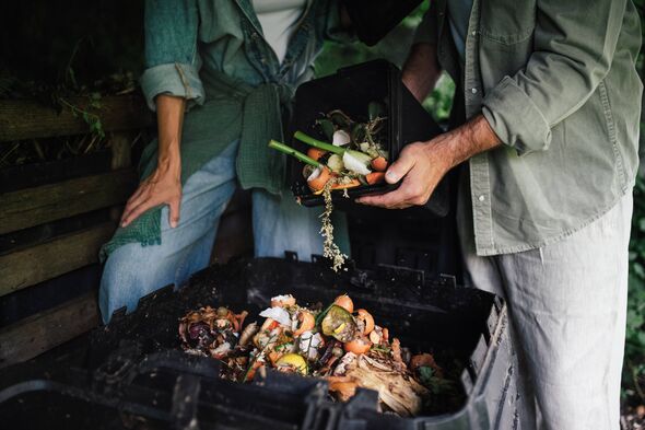 Couple dumping kitchen scraps into the composter