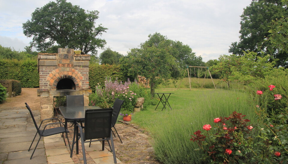 Patio with oven and rose bushes
