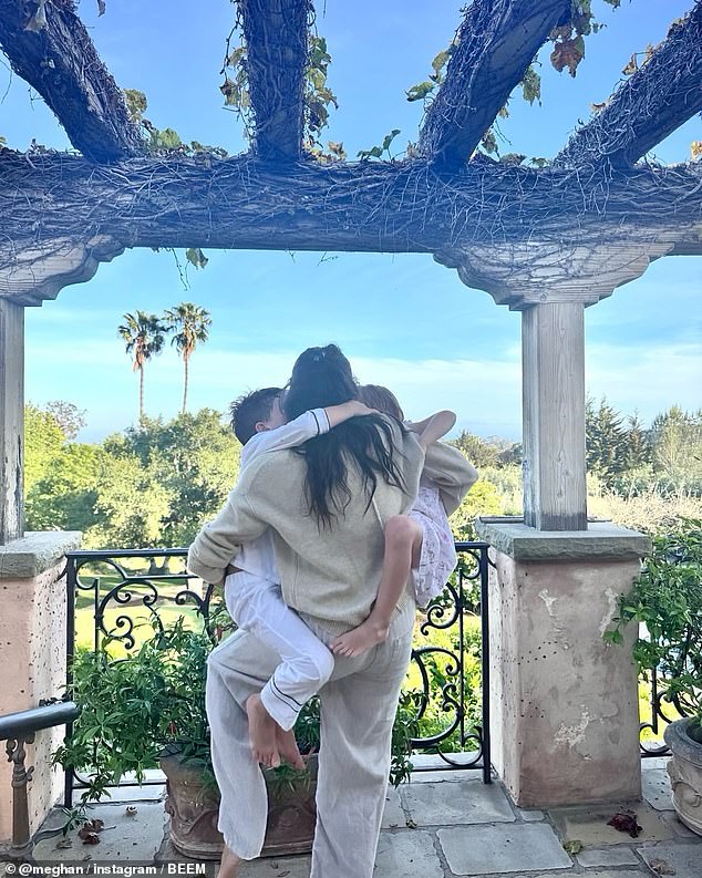 Meghan, pictured at home being climbed on by her children on Mother's Day, is said to be 'distant'  and has 'never tried to fit in' in Montecito, a journalist and neighbour has claimed