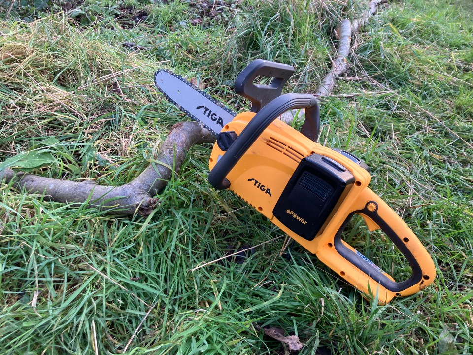 Yellow Stiga CS e300 chainsaw on the grass.
