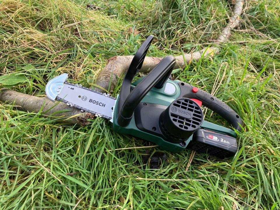 Bosch cordless chainsaw on the grass.