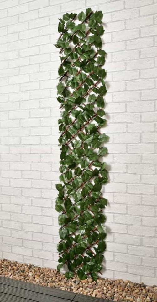 Artificial ivy leaf trellis against a brick wall.