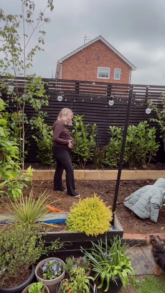 Pregnant woman standing in her garden.