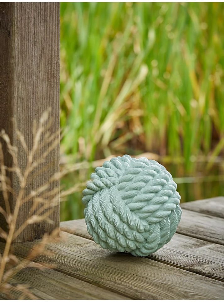 Light green resin ornament shaped like a knotted rope.