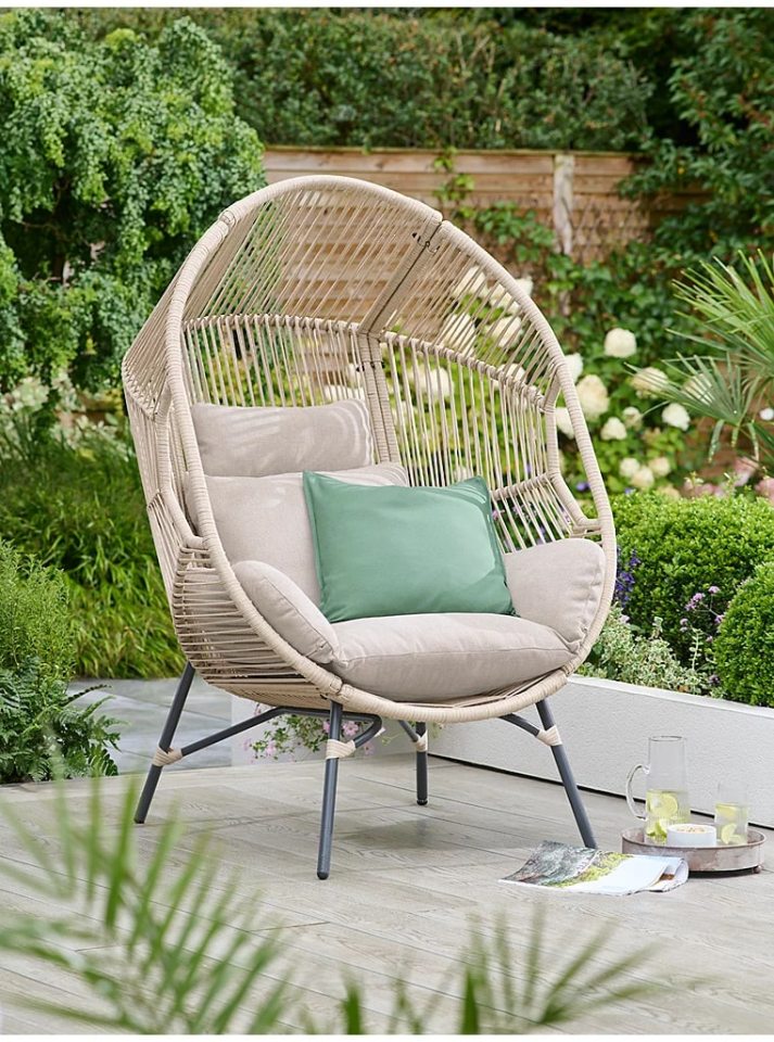 Beige egg chair with cushions on a patio.
