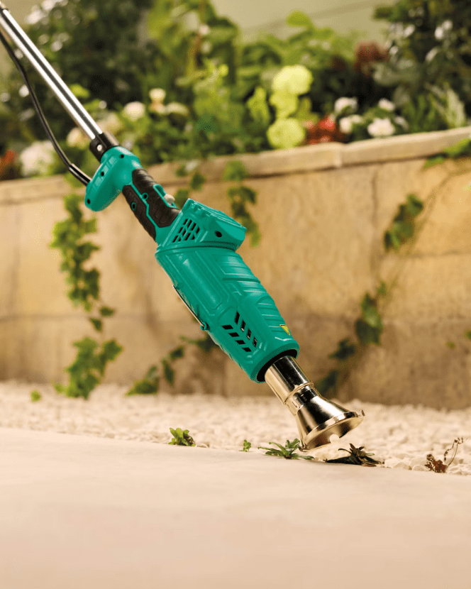 Weed burner removing weeds from a patio.