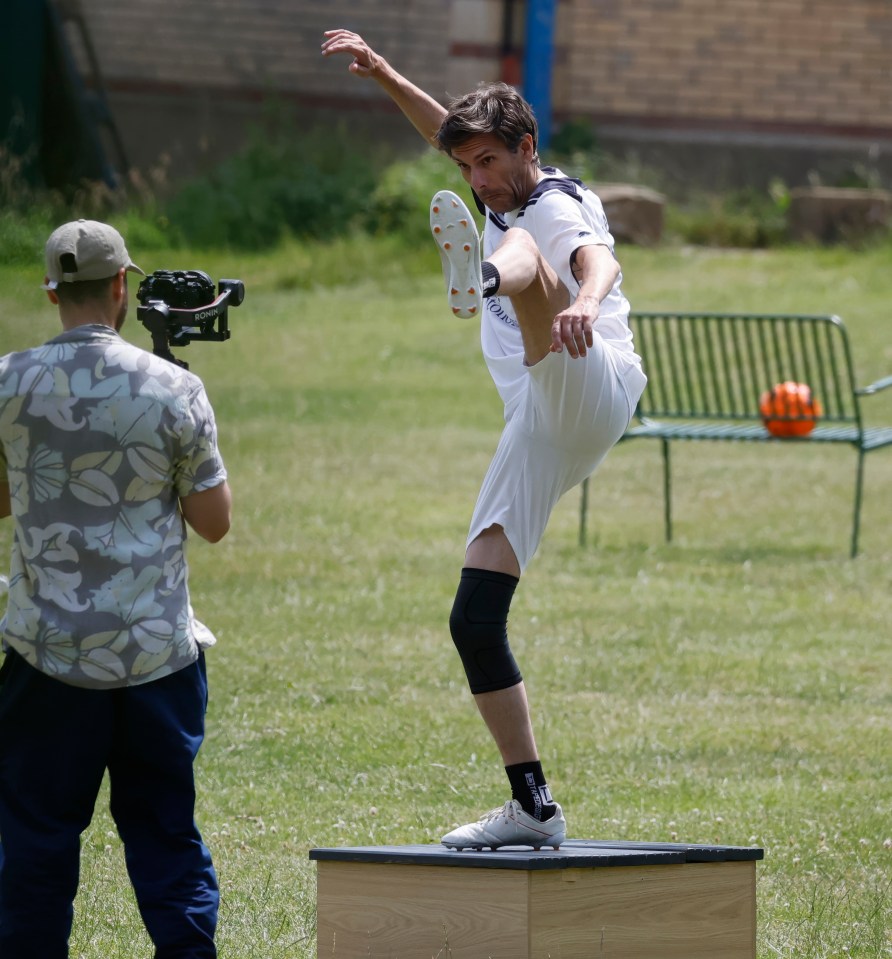 A man kicking a football during a television show filming.