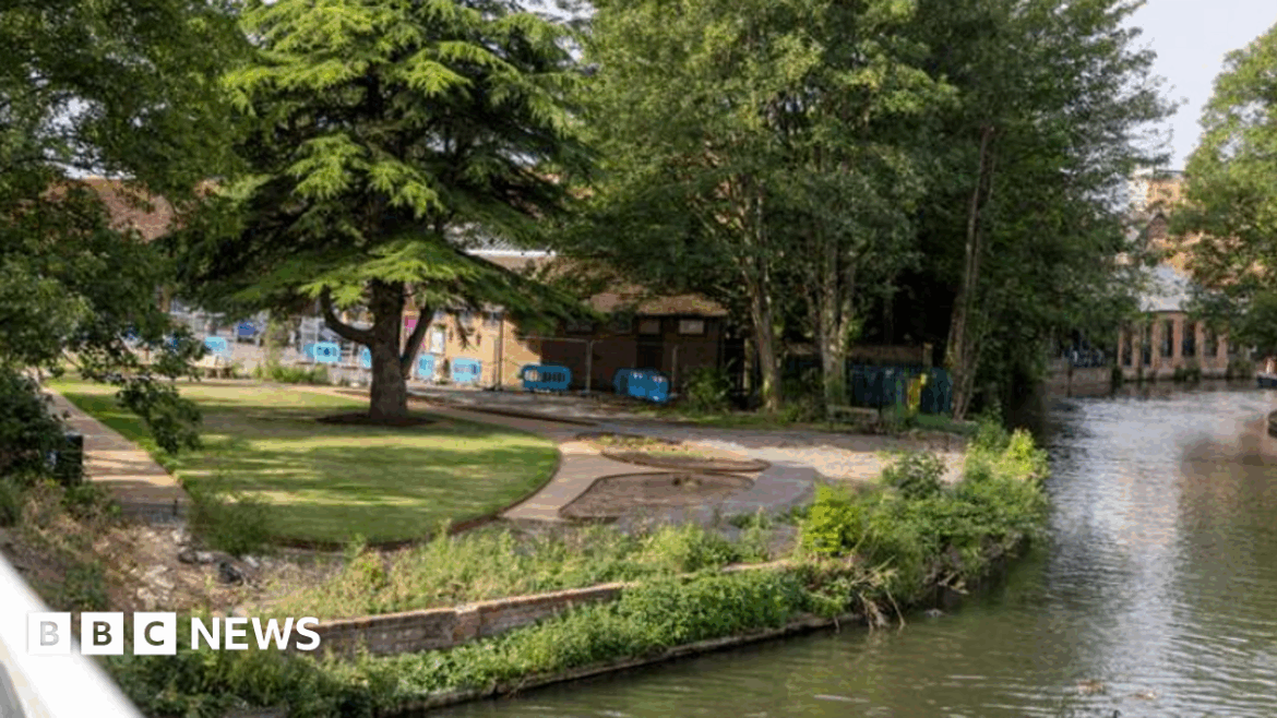 Newbury town centre Peace Garden not open despite £800k spend Newbury Peace Garden sits alongside a canal. It has grass trees and pathways - a number of blue barriers can be seen next to a building in the background.
