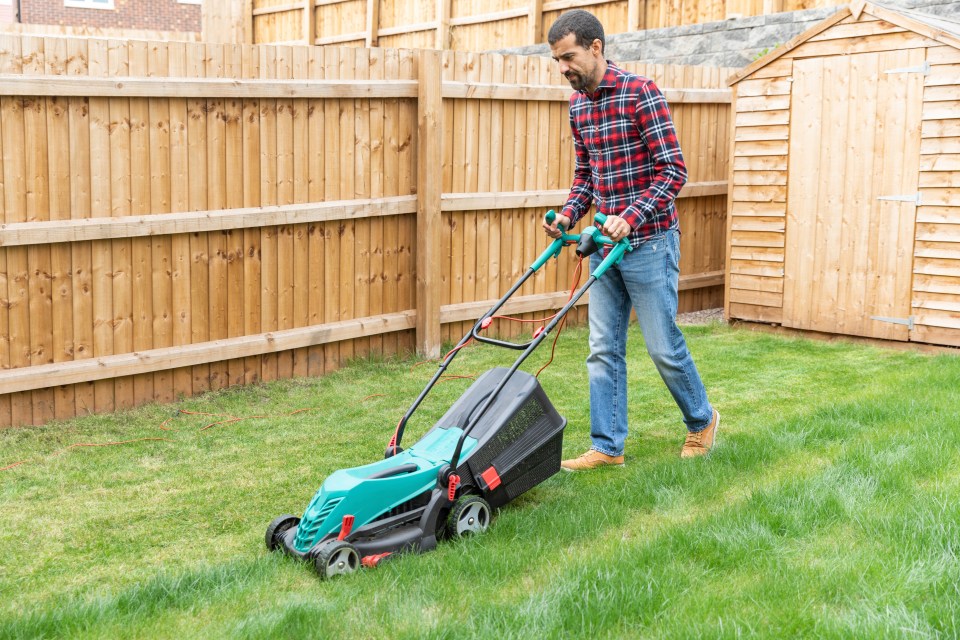 Lichfield, UK, man mowing the lawn