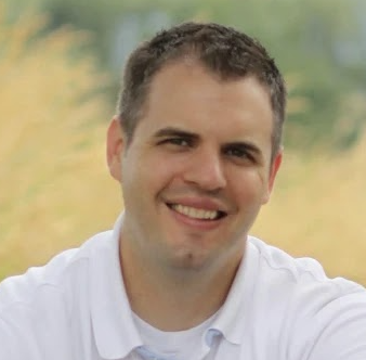 Expert headshot of a man with close cropped hair wearing a white shirt.
