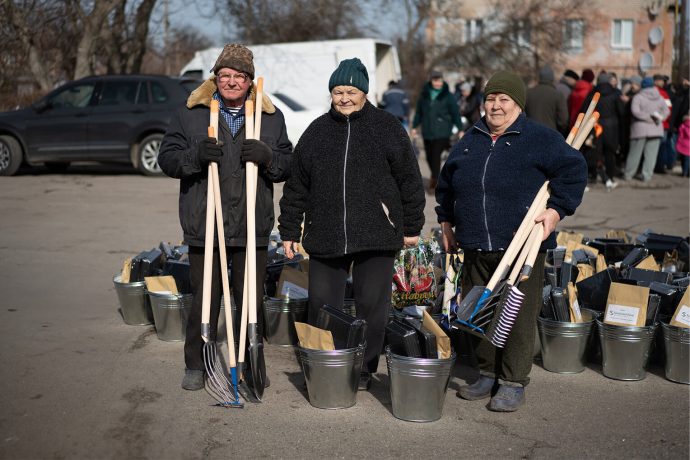 Three Ukrainians with the seeds and tools they received from Samaritan's Purse
