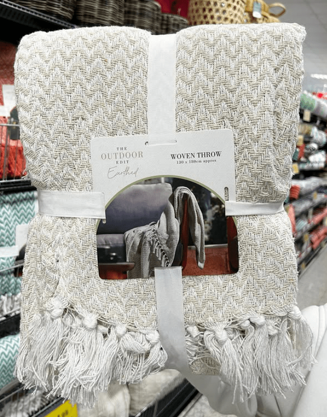 Beige woven throw blanket with fringe.