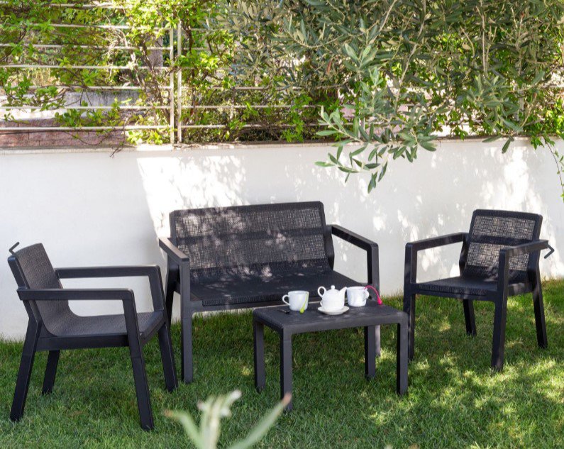 Black Riviera four-seater lounge set on a lawn.