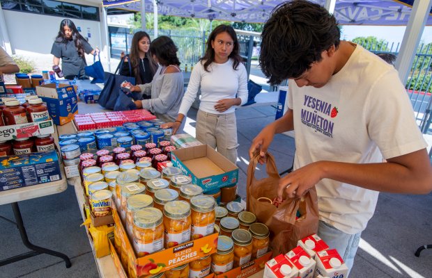 Santiago High student, Omar Diaz and others fill bags with...