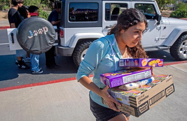 Santiago High School student Priscila Ramirez, brings in a donation...