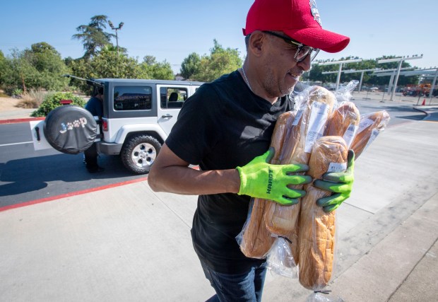 Johnny Rodriguez brings in donated bread at the Santiago High...