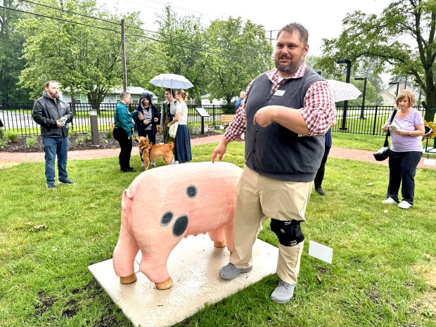 Porter County Public Library System Director Jesse Butz points to the pig that is the centerpiece of the Kouts Public Library garden dedicated Wednesday, June 18, 2025. (Doug Ross/for Post-Tribune)