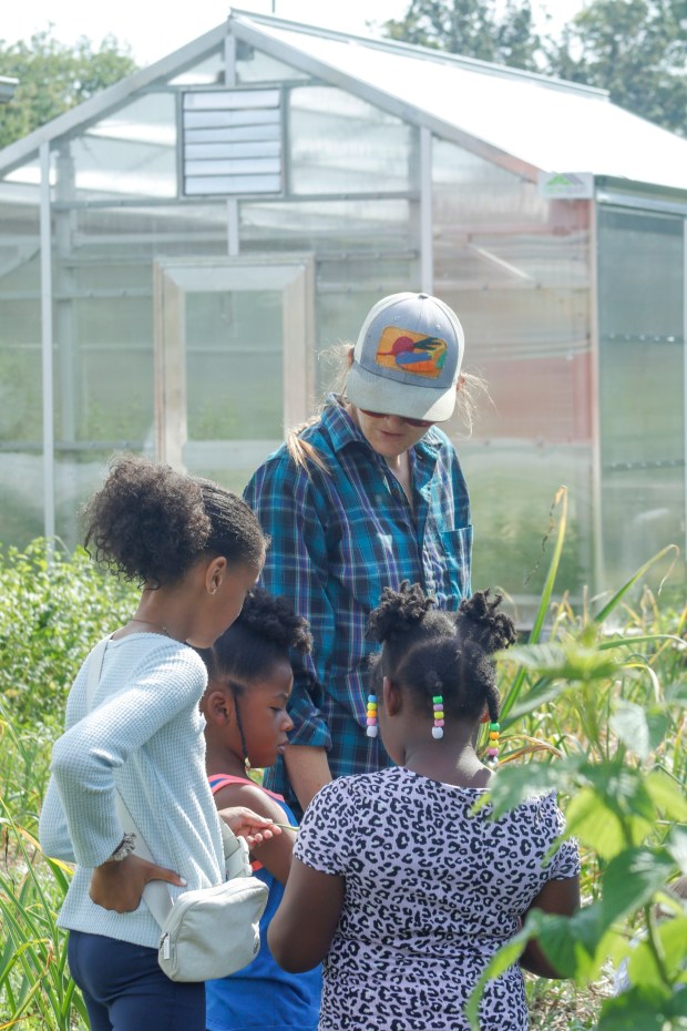 Katie Taylor, the farmer manager of Easton Urban Farm, leads children through the garden Monday, June 30, 2025, in Easton as she identifies produce and explains its growing timeline and usage. Easton Urban Farm invited children ages 5-10 for a tour of the garden, an opportunity to pick raspberries and an art session to paint a gazebo. The nonprofit, which is connected to the Neighborhood Center's Food Pantry, supplies fresh produce to low-income families. (Oliver Lois Economidis/The Morning Call)