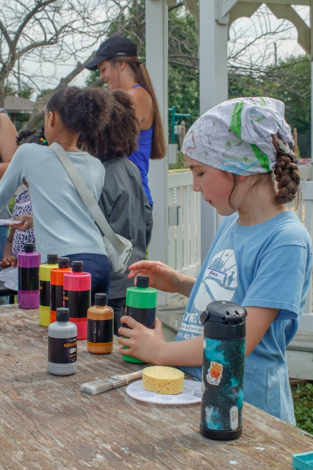 Children, staff and parents work together to paint the Easton Urban Farm's gazebo Monday, June 30, 2025. The nonprofit, which supplies fresh produce to low-income families, invited children ages 5-10 for a tour of the garden, an opportunity to pick raspberries and an art session to paint the gazebo. (Oliver Lois Economidis/The Morning Call)