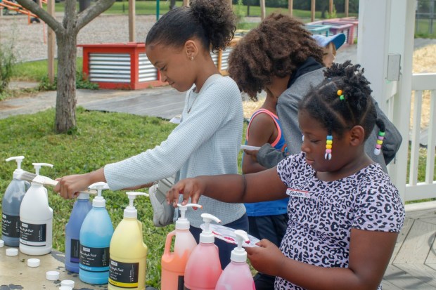 Children, staff and parents work together to paint the Easton Urban Farm's gazebo Monday, June 30, 2025. The nonprofit, which supplies fresh produce to low-income families, invited children ages 5-10 for a tour of the garden, an opportunity to pick raspberries and an art session to paint the gazebo. (Oliver Lois Economidis/The Morning Call)