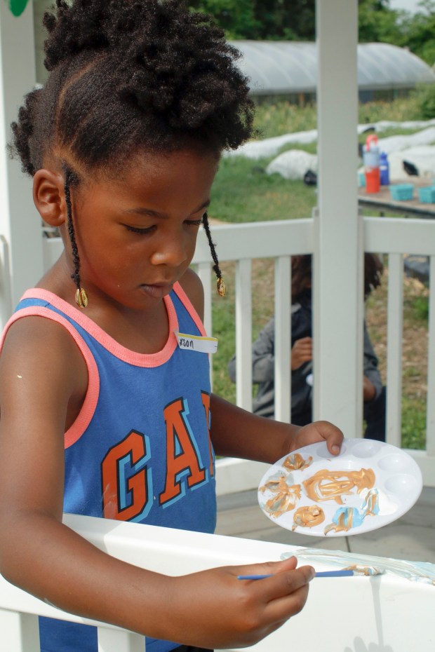 Children, staff and parents work together to paint the Easton Urban Farm's gazebo Monday, June 30, 2025. The nonprofit, which supplies fresh produce to low-income families, invited children ages 5-10 for a tour of the garden, an opportunity to pick raspberries and an art session to paint the gazebo. (Oliver Lois Economidis/The Morning Call)