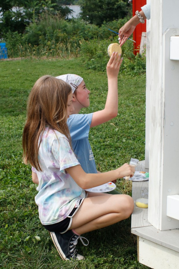 Children, staff and parents work together to paint the Easton Urban Farm's gazebo Monday, June 30, 2025. The nonprofit, which supplies fresh produce to low-income families, invited children ages 5-10 for a tour of the garden, an opportunity to pick raspberries and an art session to paint the gazebo. (Oliver Lois Economidis/The Morning Call)