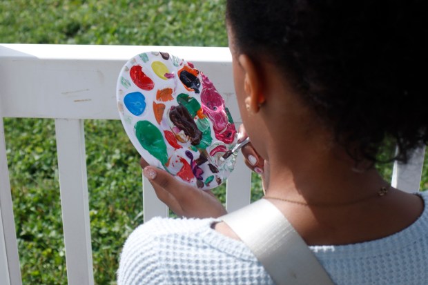 Children, staff and parents work together to paint the Easton Urban Farm's gazebo Monday, June 30, 2025. The nonprofit, which supplies fresh produce to low-income families, invited children ages 5-10 for a tour of the garden, an opportunity to pick raspberries and an art session to paint the gazebo. (Oliver Lois Economidis/The Morning Call)