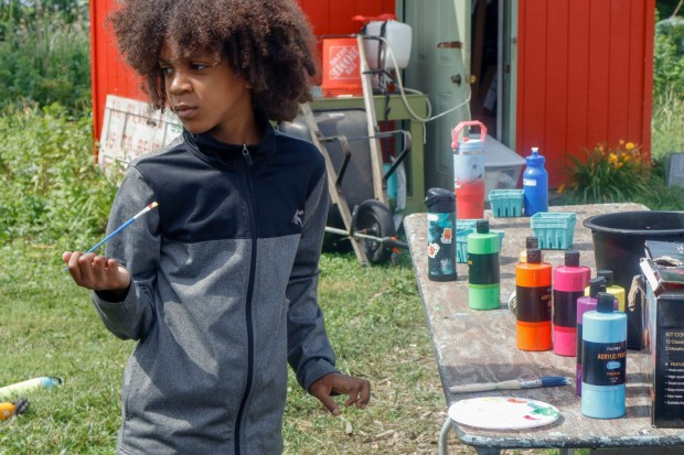 Children, staff and parents work together to paint the Easton Urban Farm's gazebo Monday, June 30, 2025. The nonprofit, which supplies fresh produce to low-income families, invited children ages 5-10 for a tour of the garden, an opportunity to pick raspberries and an art session to paint the gazebo. (Oliver Lois Economidis/The Morning Call)