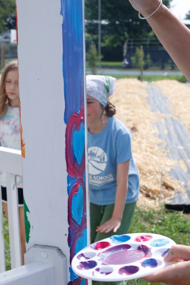 Children, staff and parents work together to paint the Easton Urban Farm's gazebo Monday, June 30, 2025. The nonprofit, which supplies fresh produce to low-income families, invited children ages 5-10 for a tour of the garden, an opportunity to pick raspberries and an art session to paint the gazebo. (Oliver Lois Economidis/The Morning Call)