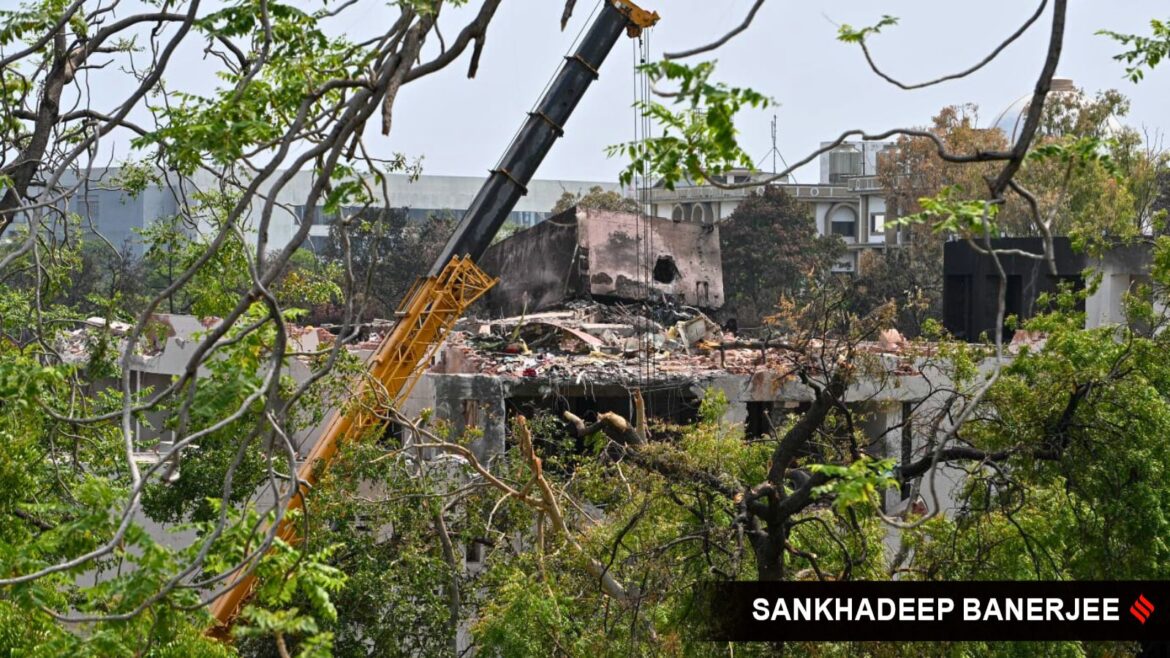 Cook who was rolling chapatis, gardener who married recently among Ahmedabad plane crash survivors on ground | Ahmedabad News A heavy-duty crane takes down the tail end of crashed Air India Boeing 787-8 Dreamliner in order to dislodge it from the building, at Meghani Nagar in Ahmedabad on Saturday. (Express Photo by Sankhadeep Banerjee)