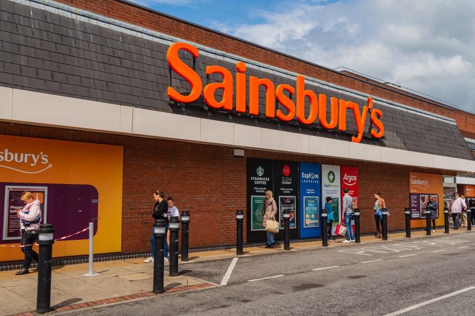 People socially distancing while queuing outside a Sainsbury's supermarket.