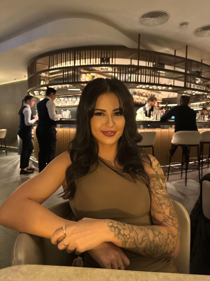 Woman with tattoos sitting at a bar.