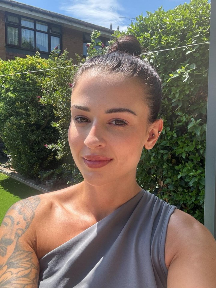 Woman in gray top sunbathing in her garden.