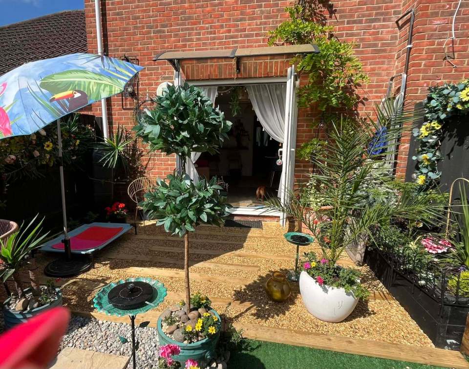 A budget-friendly garden with a patio, plants, and a tropical-themed umbrella.