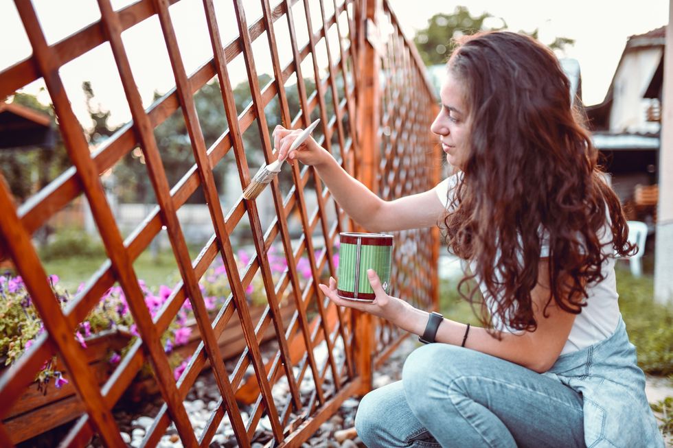 Woman painting garden fence