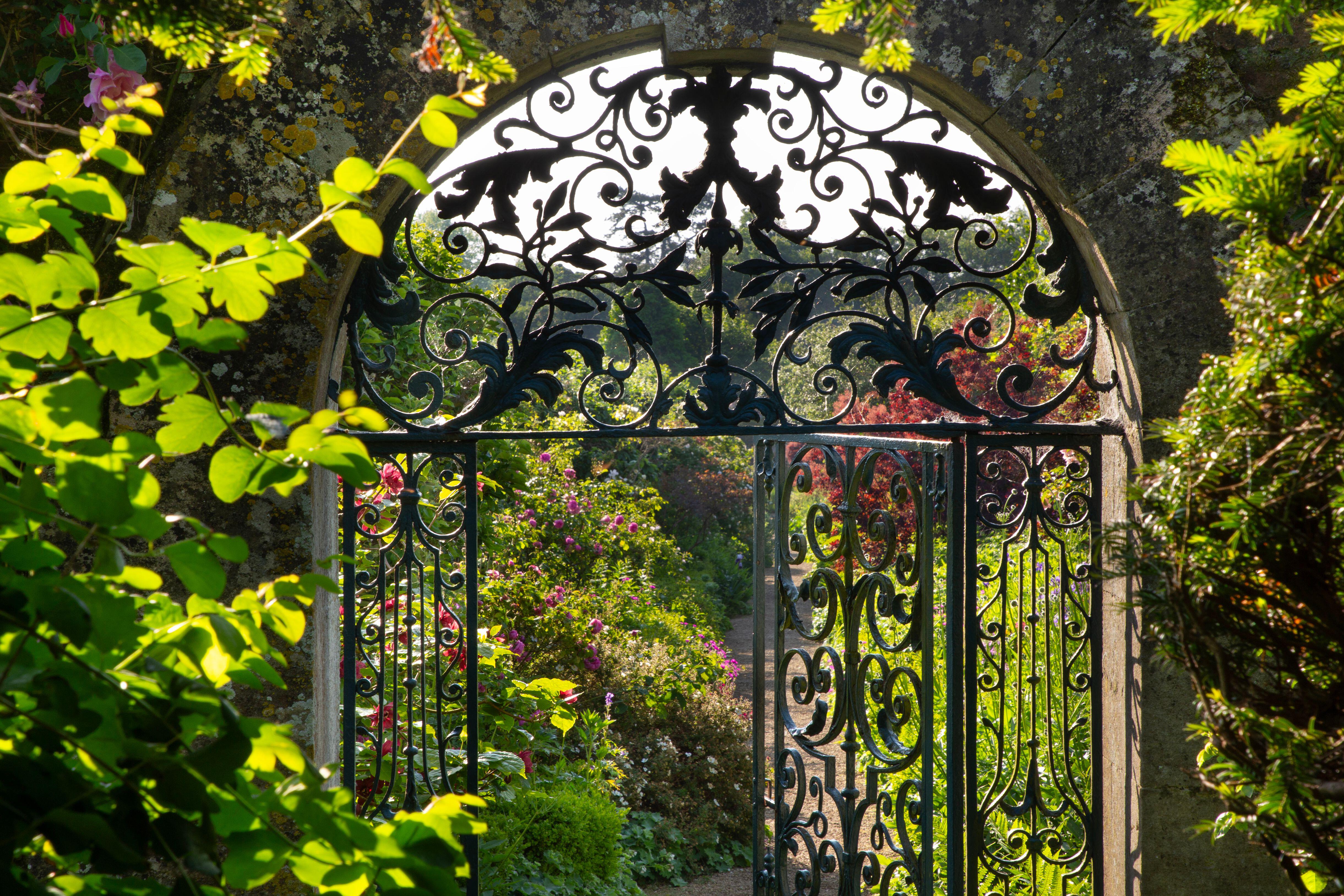 Ornate metal gateway to a garden.