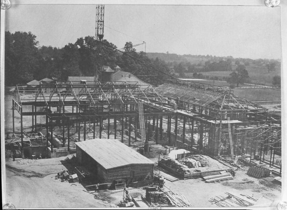 construction site with a partially built wooden structure equipment and workers
