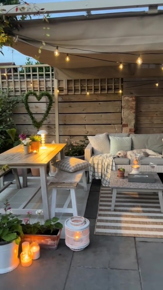 Cozy patio with string lights, seating area, and small table.