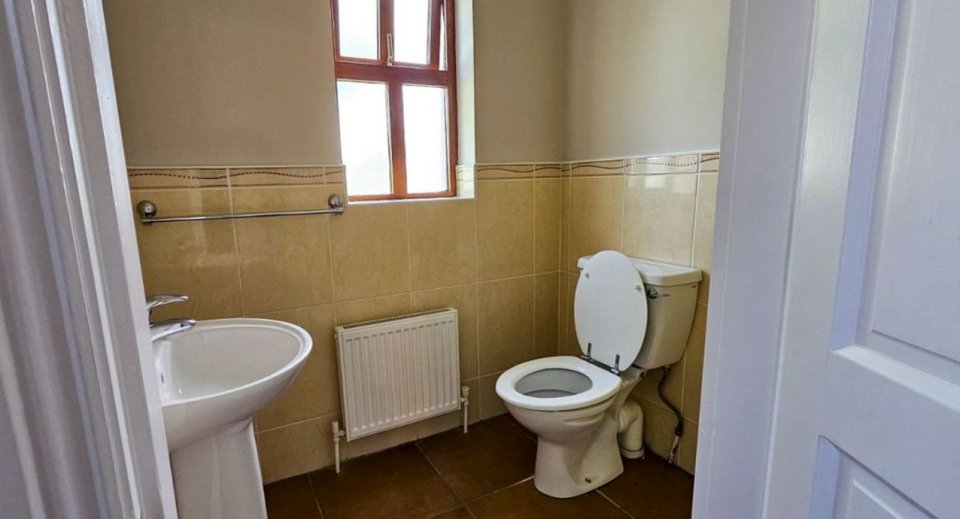 Photo of a small bathroom with a toilet and sink.