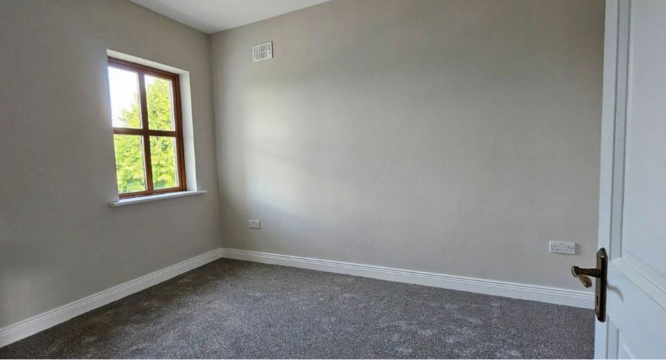 Empty room with gray carpet and a window.