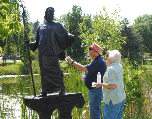 Loveland residents Alice and Dave Connor check out one of the newest sculptures in Benson Sculpture Garden, St. Patrick by artists Elijah Nugent and Jack Kreutzer. St. Patrick and another sculpture, Ridge Runners, were dedicated in the park on Saturday. There are now 189 pieces in the sculpture park. (Pamela Johnson / Loveland Reporter-Herald)