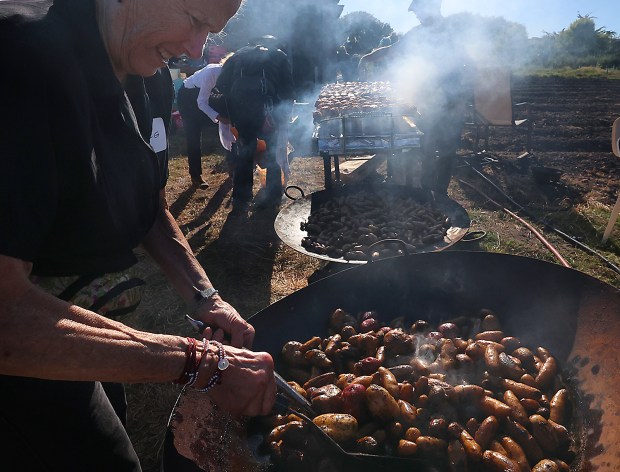 Volunteer cook (and parking attendant) Meg Sandow grills potatoes in...
