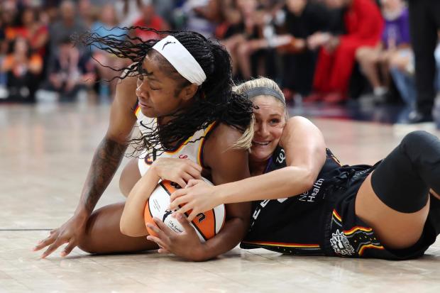 Connecticut Sun’s Jacy Sheldon, right, and Indiana Fever’s Natasha Howard...